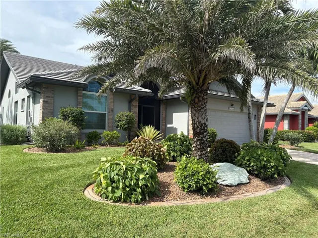 Single story home featuring stucco siding, an attached garage, and a front yard