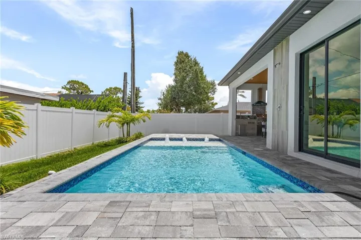 View of swimming pool featuring patio surround and a fenced backyard