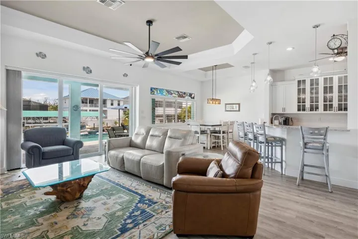 The living area is bright and open, with large sliding glass doors that create a seamless transition to the pool area outside.