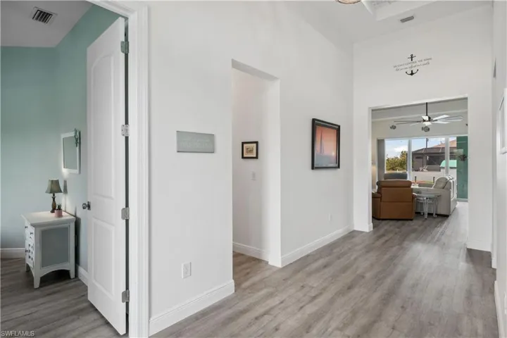 As you enter, you are greeted by an open, airy area with high ceilings and elegant flooring, creating an inviting first impression.