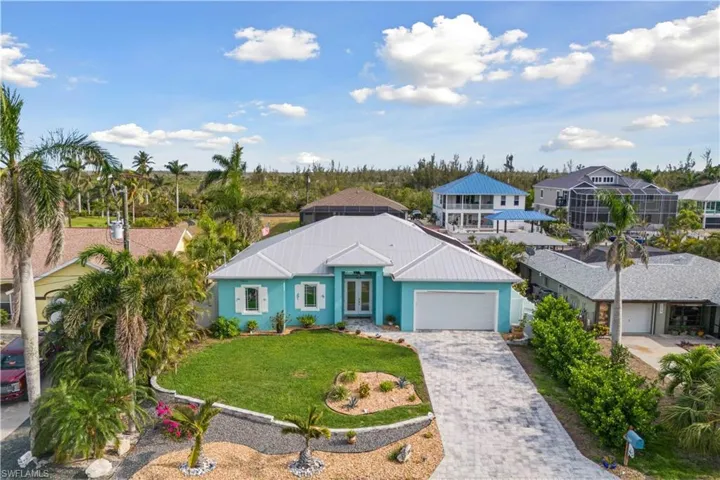 The front view of the home showcases a beautifully maintained exterior with a wide paver driveway and walkway that add elegance and curb appeal.