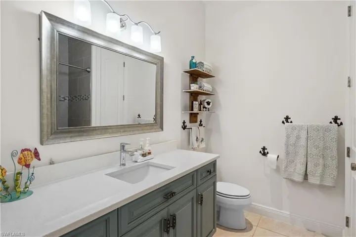 The guest bathroom is beautifully appointed with modern fixtures, a sleek vanity, and a fully tiled shower/tub combination.