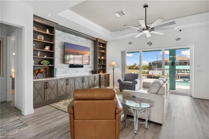 The living area is warm and inviting, featuring built-in shelves that offer both style and function, perfect for displaying books, decor, or personal touches.