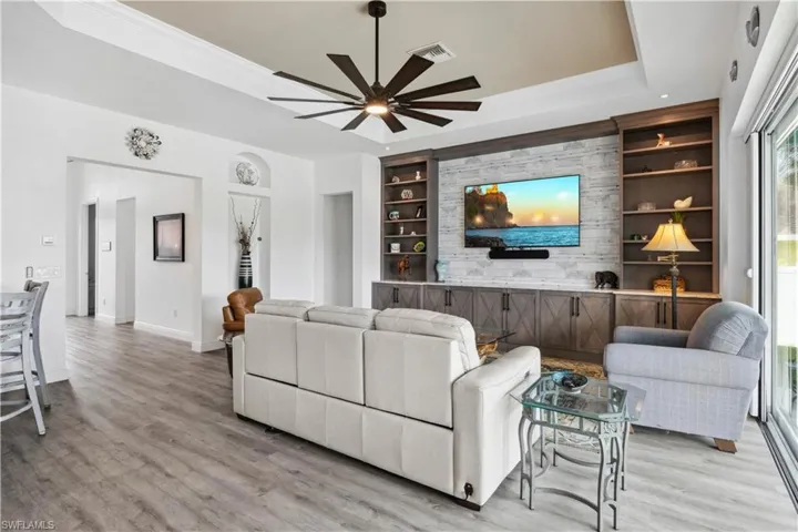 The combination of custom shelving and stone detailing creates a cozy yet refined atmosphere, ideal for relaxing or entertaining.