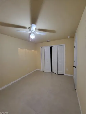 Unfurnished bedroom featuring a ceiling fan, a closet, visible vents, and baseboards