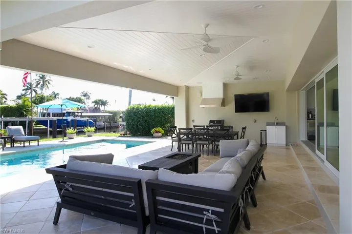View of patio featuring an outdoor living space with a fire pit, outdoor dining area, and a ceiling fan