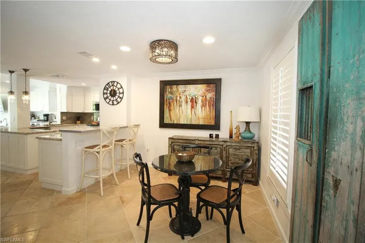 Dining area with crown molding, recessed lighting, and light tile patterned floors