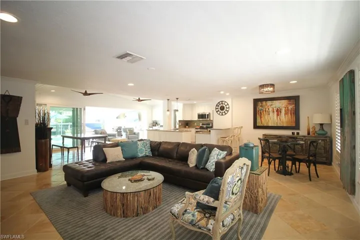 Living room with crown molding, healthy amount of natural light, recessed lighting, and ceiling fan