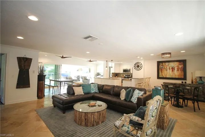 Living room with recessed lighting, crown molding, ceiling fan, and light tile patterned floors