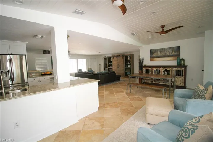 Living room with ceiling fan and lofted ceiling