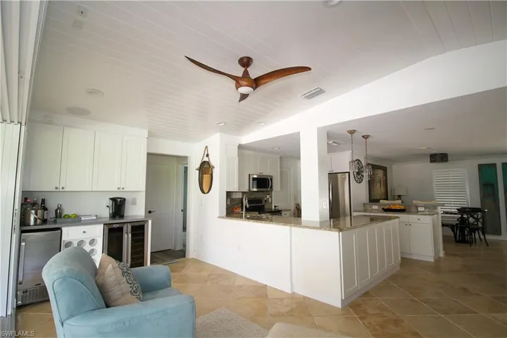 Kitchen featuring a peninsula, white cabinets, appliances with stainless steel finishes, dark stone countertops, and open floor plan