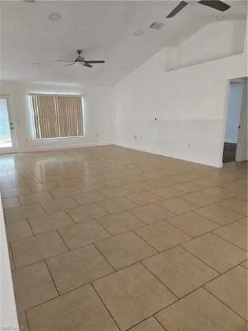 Kitchen features stainless appliances, a double sink, fridge,/freezer, custom tiled backsplash, and warm brown cabinets with silver-tone hardware.