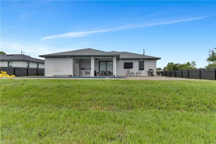Rear view of house featuring a patio and a lawn