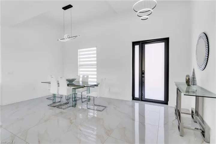 Tiled dining room with a healthy amount of sunlight and a high ceiling