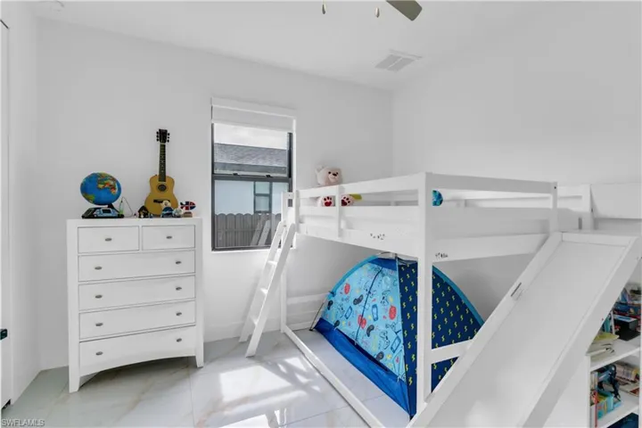 Bedroom with light tile patterned flooring and ceiling fan