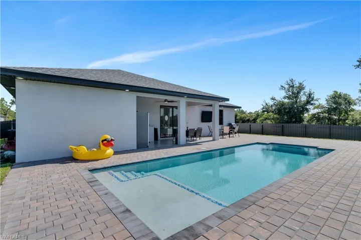 View of swimming pool featuring a patio and ceiling fan