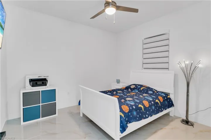 Tiled bedroom featuring ceiling fan