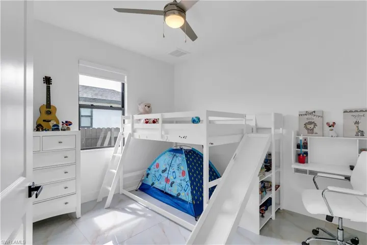 Tiled bedroom featuring ceiling fan