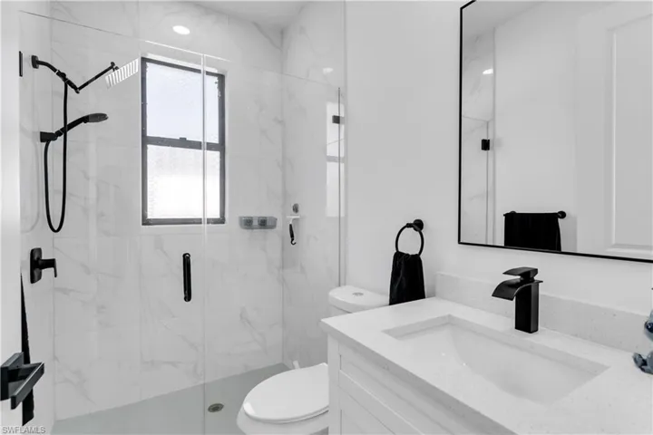 Bathroom with vanity, toilet, and an enclosed shower