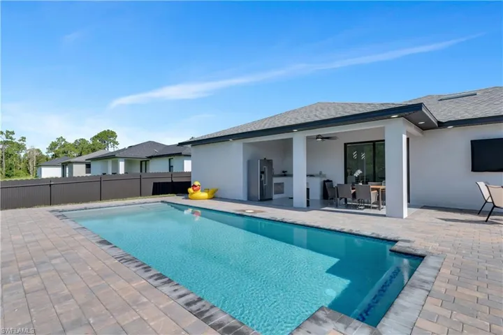 View of swimming pool featuring a patio and ceiling fan