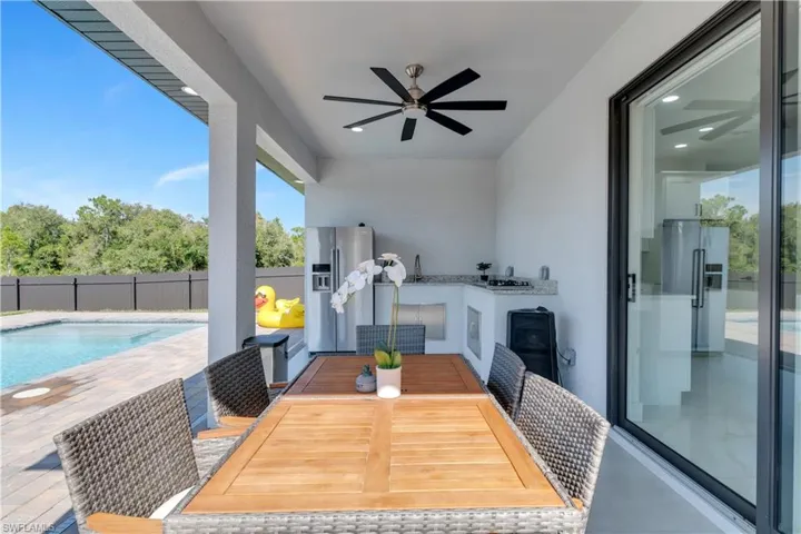 View of patio with ceiling fan and a fenced in pool