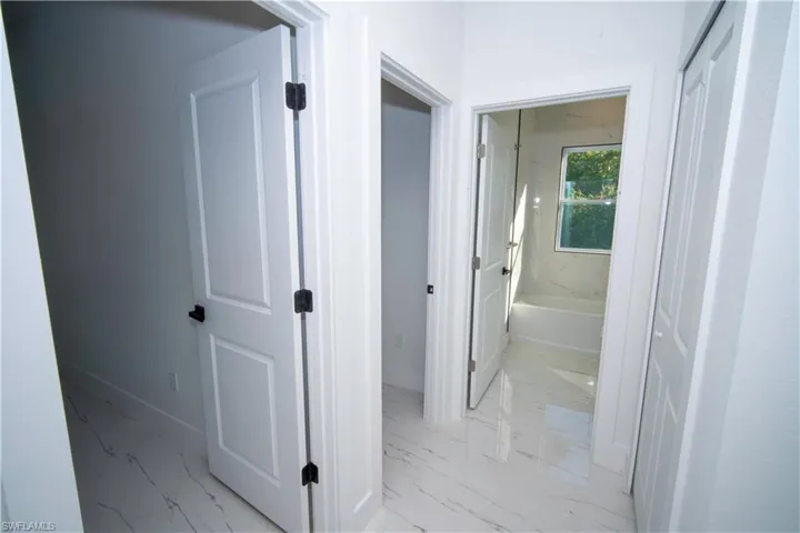 Hallway with baseboards and light marble finish floors