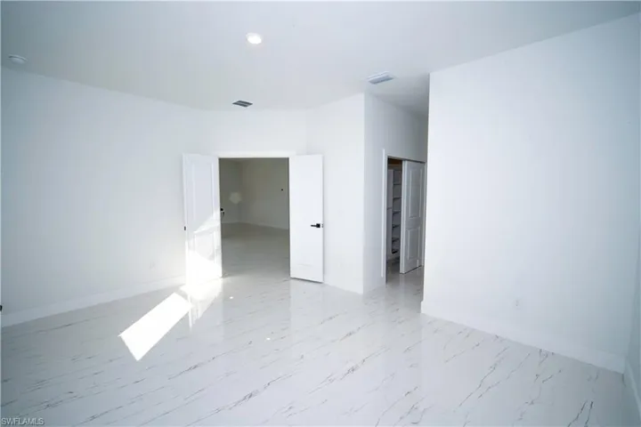 Spare room featuring baseboards and light marble finish flooring