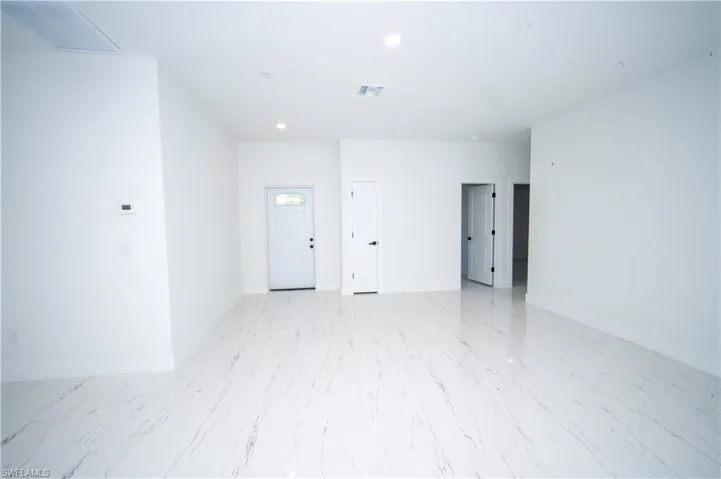 Empty room with baseboards and recessed lighting