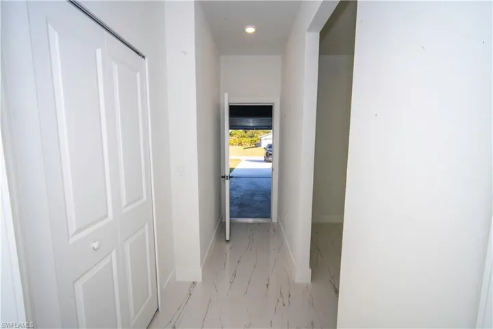 Hall featuring recessed lighting and light marble finish floors
