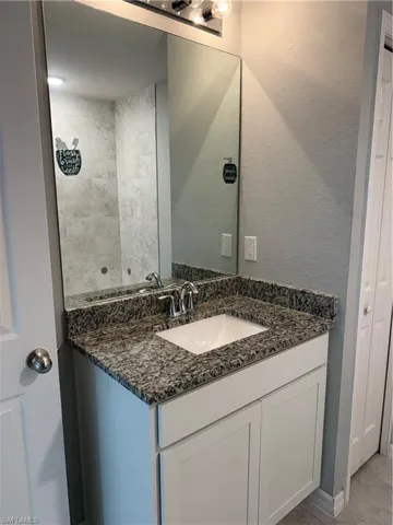 Bathroom with vanity and a textured wall