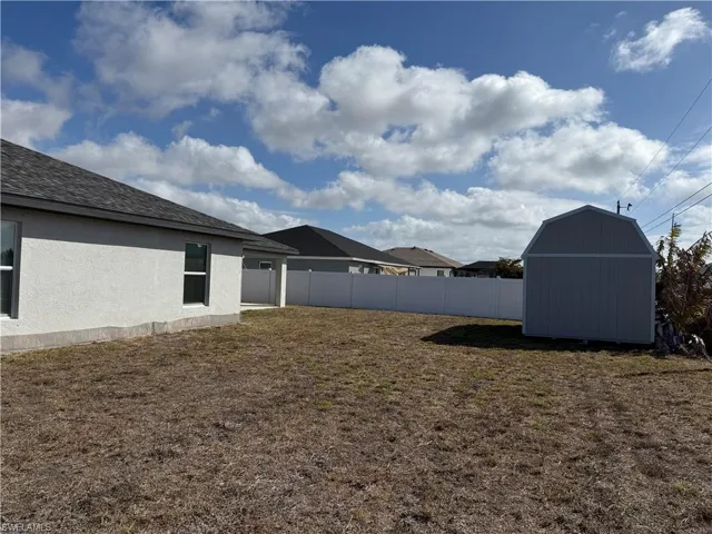 Fenced backyard featuring a storage shed
