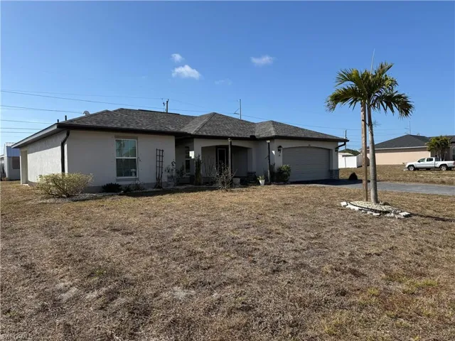 Ranch-style house featuring stucco siding, an attached garage, a shingled roof, asphalt driveway, and a front lawn