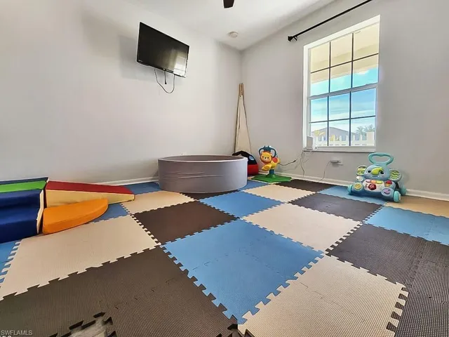 Exercise room with baseboards and a ceiling fan