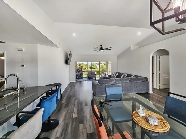 Dining room featuring arched walkways, recessed lighting, dark wood-type flooring, ceiling fan, and lofted ceiling