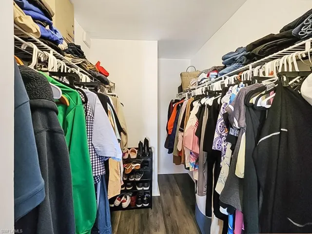 Walk in closet featuring dark wood finished floors