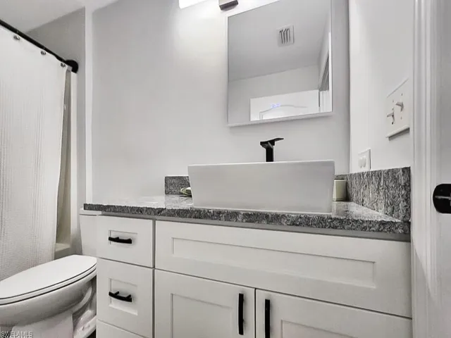 Full bathroom with shower / bath combo with shower curtain and vanity