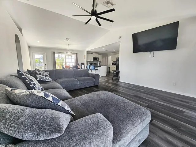 Living area featuring ceiling fan and dark wood-style flooring