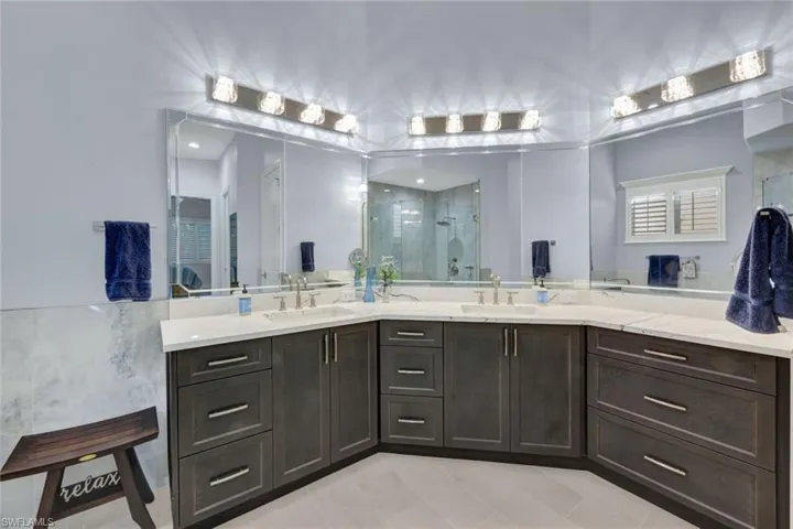 Bathroom featuring a shower stall and double vanity