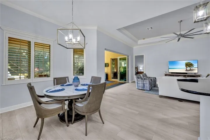 Dining area featuring crown molding, a new chandelier, new light vinyl planked flooring.