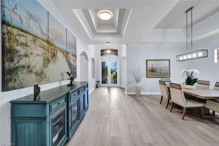 Entry way, new vinyl plank flooring, updated designer light fixtures and hurricane impact front doors.
