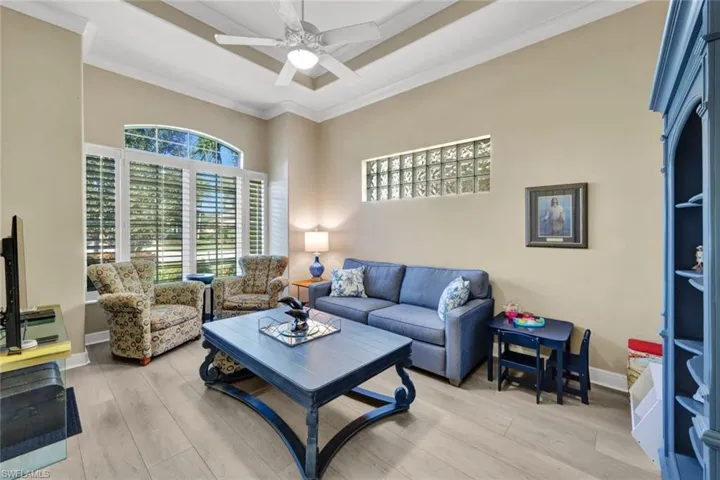 Den or flex room with vinyl flooring, crown molding, and ceiling fan