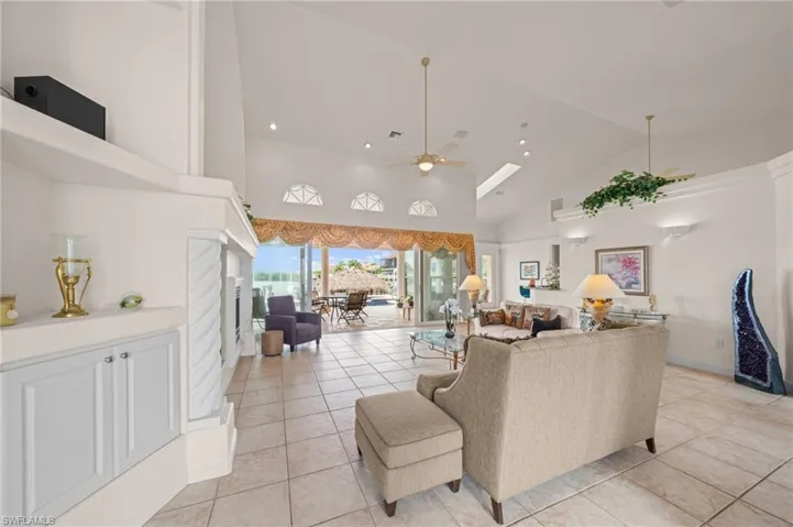 Living room featuring high vaulted ceiling, ceiling fan, light tile patterned floors, and recessed lighting
