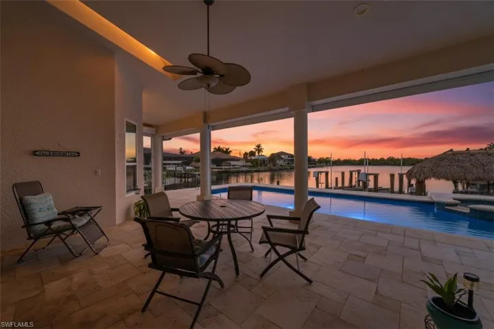 View of pool featuring a patio area, a pool with connected hot tub, ceiling fan, and a water view
