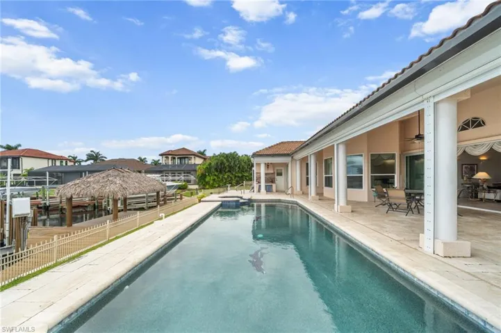 View of pool with a patio, a ceiling fan, and a pool with connected hot tub