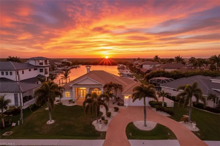 Mediterranean / spanish-style house with decorative driveway, a lawn, a residential view, and a water view