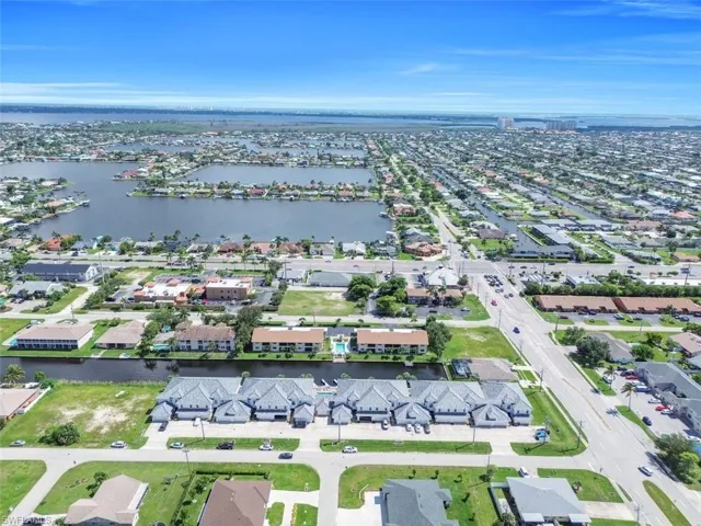 Aerial view of property and surrounding area with a large body of water and nearby suburban area