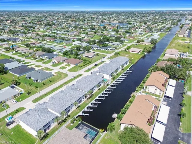 Aerial view of property and surrounding area with a nearby body of water and nearby suburban area