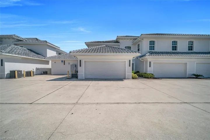 Mediterranean / spanish home with stucco siding, driveway, an attached garage, and a tiled roof