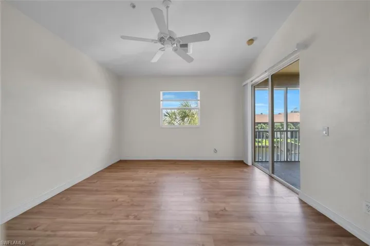 Empty room featuring plenty of natural light, light wood-type flooring, and a ceiling fan