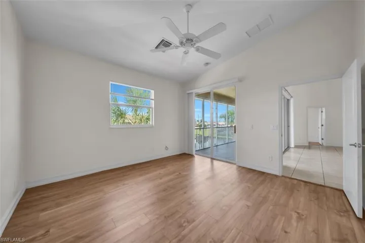 Unfurnished room with light wood finished floors, vaulted ceiling, and ceiling fan